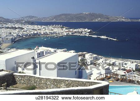 Stock Image -  Mykonos, Greek Islands, Cyclades, Greece, Europe, Resort with swimming pool and view of Mykonos Harbor on the Aegean Sea.. Fotosearch