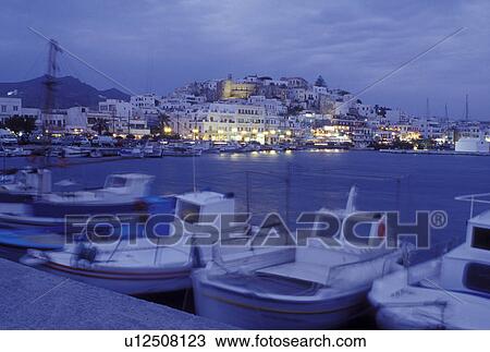 Stock Image -  Naxos, Greece, Greek Islands, Cyclades, Europe, Fishing boats docked in Hora Naxos Harbor in the evening on Naxos Island on the Aegean Sea.. Fotosearch