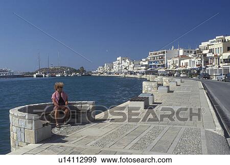 Naxos, Greek Islands, Cyclades, Greece, Europe, Woman sitting on the waterfront on Hora Naxos Harbor on Naxos Island on the Aegean Sea. View Large Photo Image Stock Photo - Naxos, Greek Islands, Cyclades, Greece, Europe, Woman sitting on the waterfront on Hora Naxos Harbor on Naxos Island on the Aegean Sea.. Fotosearch