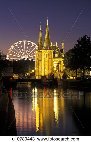 Stock Image -  Netherlands, Sneek, Holland, Friesland, Europe, Water Tower (1613) along the canal in downtown Sneek illuminated at night.. Fotosearch