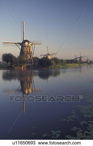 Netherlands, windmill, canal, Kinderdijk, Holland, Zuid-Holland, Europe, Mills of Kinderdijk, Working windmills along a canal in the early morning in Kinderdijk. View Large Photo Image Stock Image - Netherlands, windmill, canal, Kinderdijk, Holland, Zuid-Holland, Europe, Mills of Kinderdijk, Working windmills along a canal in the early morning in Kinderdijk. . Fotosearch