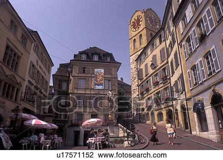 Stock Image -  outdoor cafT, clock tower, Switzerland, Neuchatel, Outdoor cafT and clock tower at the historic crossroads of Croix du Marche in downtown Neuchatel.. Fotosearch