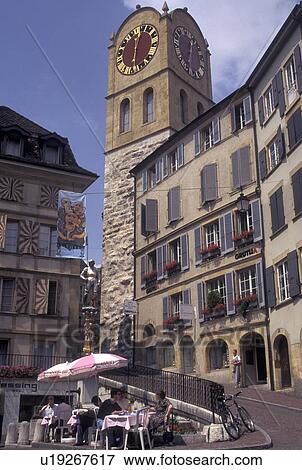Stock Photo -  outdoor cafT, clock tower, Switzerland, Neuchatel, Outdoor cafT and clock tower at Croix du Marche in downtown Neuchatel.. Fotosearch