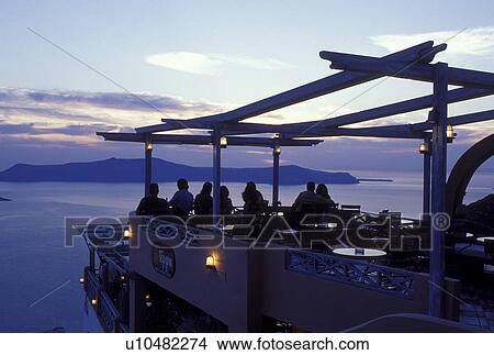 outdoor cafT, Greece, Santorini, Greek Islands, Fira, Cyclades, Europe, Outdoor restaurant overlooking the Aegean Sea at sunset in the village of Fira on Santorini Island. View Large Photo Image Picture - outdoor cafT, Greece, Santorini, Greek Islands, Fira, Cyclades, Europe, Outdoor restaurant overlooking the Aegean Sea at sunset in the village of Fira on Santorini Island.. Fotosearch