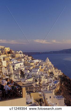 Picture -  outdoor cafT, Santorini, Greek Islands, Fira, Cyclades, Greece, Europe, Outdoor restaurants and terraces in the village of Fira on the steep hillside of Santorini Island overlooking the Aegean Sea.. Fotosearch