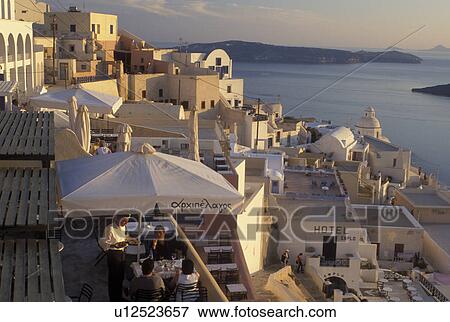 Stock Photo -  outdoor cafT, Santorini, Greek Islands, Fira, Cyclades, Greece, Europe, Outdoor restaurant in the village of Fira on the steep hillside of Santorini Island overlooking the Aegean Sea.. Fotosearch