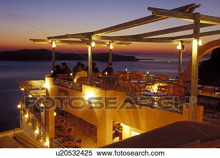 outdoor cafT, Santorini, Greek Islands, Fira, Cyclades, Greece, Europe, Outdoor restaurant overlooking the Aegean Sea in the evening in the village of Fira on Santorini Island. View Large Photo Image Stock Photography - outdoor cafT, Santorini, Greek Islands, Fira, Cyclades, Greece, Europe, Outdoor restaurant overlooking the Aegean Sea in the evening in the village of Fira on Santorini Island.. Fotosearch