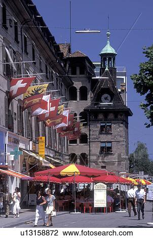 Stock Image -  outdoor cafT, Switzerland, Geneva, Outdoor cafT with red umbrellas at Place du Molard in the old town of the city of Geneva.. Fotosearch