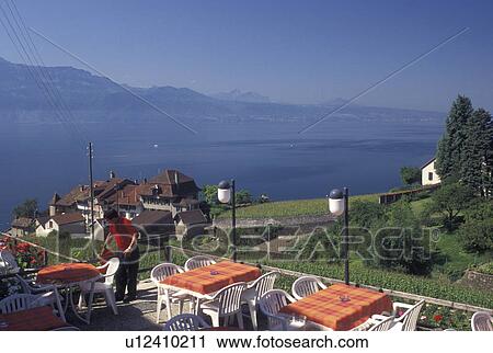 Stock Image -  outdoor cafT, Switzerland, Lavaux, Lake Geneva, Vaud, Outdoor cafT in the village of Epesses with a scenic view of Lac Leman and the vineyards of Lavaux in the Canton of Vaud. . Fotosearch