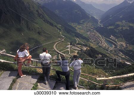 overlook, Switzerland, Ticino, Airolo, Val Leventina, Alps, St. Gotthard Pass Road, People looking out at the beautiful scenery on Saint Gotthard Mountain Pass in the scenic Swiss Alps. View Large Photo Image Stock Image - overlook, Switzerland, Ticino, Airolo, Val Leventina, Alps, St. Gotthard Pass Road, People looking out at the beautiful scenery on Saint Gotthard Mountain Pass in the scenic Swiss Alps.. Fotosearch