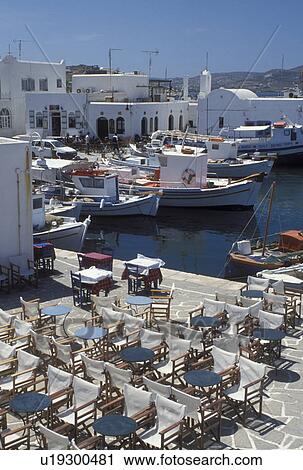 Stock Image -  Paros, Greece, Greek Islands, Naoussa, Cyclades, Europe, Outdoor cafT on the waterfront on Naoussa Harbor on Paros Island on the Aegean Sea.. Fotosearch