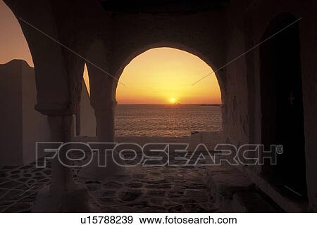 Stock Photo -  Paros, Greek Islands, Greece, Parikia, Cyclades, Europe, Sunset over the Aegean Sea from the terrace of a whitewashed church in the town of Parikia on Paros Island.. Fotosearch