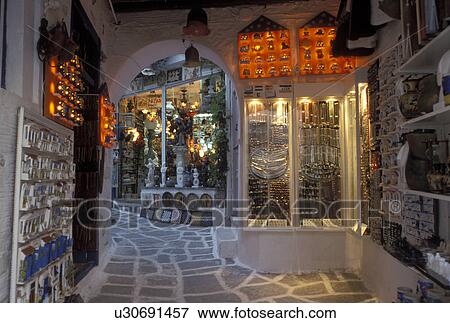 Paros, Greek Islands, Parikia, Cyclades, Greece, Europe, Shops along the narrow pedestrian streets in Plateia Mavrogenous in the evening in the town of Parikia on Paros Island. View Large Photo Image Stock Photo - Paros, Greek Islands, Parikia, Cyclades, Greece, Europe, Shops along the narrow pedestrian streets in Plateia Mavrogenous in the evening in the town of Parikia on Paros Island.. Fotosearch