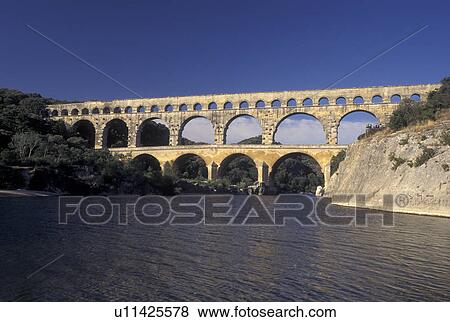 Stock Photo -  Pont du Gard, aqueduct, France, Languedoc-Roussillon, Europe, Three-tiered 19 BC Roman Aqueduct, Pont du Gard spans the Gardon River.. Fotosearch