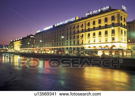 Stock Image -  Rhone River, Geneva, Switzerland, Buildings along the Rhone River in downtown Geneva at night. . Fotosearch
