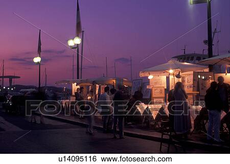 St. Tropez, France, Cote d' Azur, Provence, Var, Europe, Street artists display artwork along the waterfront in Saint Tropez in the evening on the Mediterranean Sea. View Large Photo Image Stock Photograph - St. Tropez, France, Cote d' Azur, Provence, Var, Europe, Street artists display artwork along the waterfront in Saint Tropez in the evening on the Mediterranean Sea.. Fotosearch