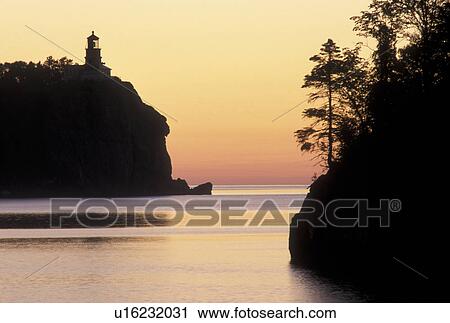 Stock Image -  sunrise, lighthouse, Lake Superior, North Shore Drive, Two Harbors, MN, Minnesota, Split Rock Lighthouse situated on a high cliff on the north shore of Lake Superior at Split Rock Lighthouse State Park in Two Harbors at sunrise.. Fotosearch