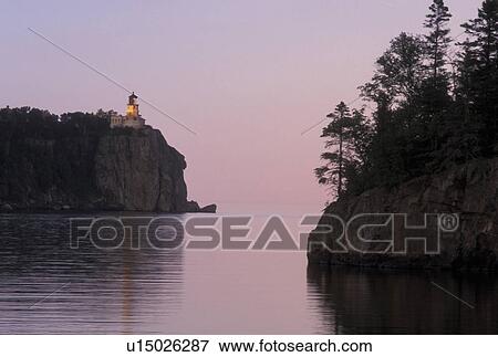 Stock Photo -  sunset, lighthouse, Lake Superior, North Shore Drive, Two Harbors, MN, Minnesota, Split Rock Lighthouse situated on a high cliff on the north shore of Lake Superior at Split Rock Lighthouse State Park in Two Harbors at sunset.. Fotosearch