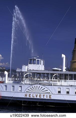 Switzerland, Geneva, Lake Geneva, Jet d' Eau sprays above a paddlewheel sightseeing boat docked at the marina in the harbor of Lac Leman in Geneva. View Large Photo Image Stock Photo - Switzerland, Geneva, Lake Geneva, Jet d' Eau sprays above a paddlewheel sightseeing boat docked at the marina in the harbor of Lac Leman in Geneva. . Fotosearch