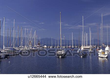 Switzerland, La Cote, Vaud, Lake Geneva, Boats docked in the harbor along the lakefront in the town of Morges on Lac Leman. View Large Photo Image Picture - Switzerland, La Cote, Vaud, Lake Geneva, Boats docked in the harbor along the lakefront in the town of Morges on Lac Leman.. Fotosearch