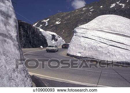 Switzerland, Ticino, Alps, Saint Gotthard Pass Road, Snow piled on the side of the mountain road at the summit of St. Gotthard Mountain Pass in the scenic Swiss Alps in the summer. View Large Photo Image Stock Image - Switzerland, Ticino, Alps, Saint Gotthard Pass Road, Snow piled on the side of the mountain road at the summit of St. Gotthard Mountain Pass in the scenic Swiss Alps in the summer.. Fotosearch