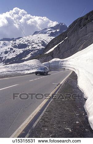 Switzerland, Valais, Furka Pass, Alps, Snow along the Furka Mountain Pass Road in the Swiss Alps in the summer. View Large Photo Image Stock Image - Switzerland, Valais, Furka Pass, Alps, Snow along the Furka Mountain Pass Road in the Swiss Alps in the summer.. Fotosearch