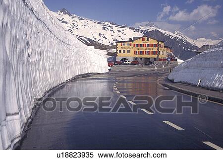 Switzerland, Valais, Grimsel Pass, Alps, Snow piled high next to the mountain road leading to the Grimsel-Blick Hotel-Restaurant in the summer on the summit of Grimsel Pass the Swiss Alps in the Canton of Valais. View Large Photo Image Stock Photography - Switzerland, Valais, Grimsel Pass, Alps, Snow piled high next to the mountain road leading to the Grimsel-Blick Hotel-Restaurant in the summer on the summit of Grimsel Pass the Swiss Alps in the Canton of Valais.. Fotosearch