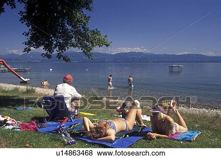 Switzerland, Vaud, Lake Geneva, La Cote, A family enjoying a day in the sun on the beach in Perroy along Lac Leman in the Canton of Vaud. View Large Photo Image Stock Photo - Switzerland, Vaud, Lake Geneva, La Cote, A family enjoying a day in the sun on the beach in Perroy along Lac Leman in the Canton of Vaud.. Fotosearch