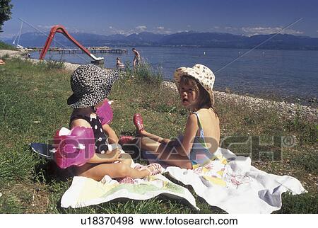 Switzerland, Vaud, Lake Geneva, La Cote, Two young girls enjoying a day in the sun on the beach in Perroy along Lac Leman in the Canton of Vaud. View Large Photo Image Stock Photo - Switzerland, Vaud, Lake Geneva, La Cote, Two young girls enjoying a day in the sun on the beach in Perroy along Lac Leman in the Canton of Vaud.. Fotosearch