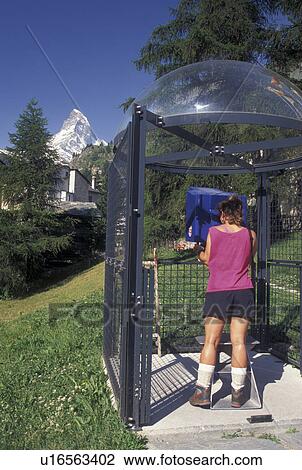 Switzerland, Zermatt, Valais, Alps, Woman looks through a telescope at the Matterhorn in the village of Zermatt in the Canton of Valais in the Swiss Alps. View Large Photo Image Stock Image - Switzerland, Zermatt, Valais, Alps, Woman looks through a telescope at the Matterhorn in the village of Zermatt in the Canton of Valais in the Swiss Alps.. Fotosearch