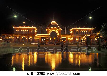 Stock Photo -  Tivoli Gardens, Copenhagen, Denmark, Scandinavia, Sjaelland, Europe, Lights at the entrance to Tivoli Amusement Park reflect in the pond at night.. Fotosearch