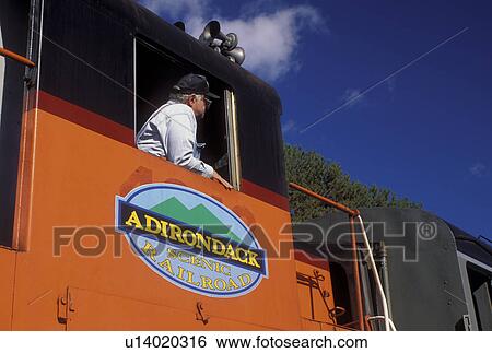 train, Saranac Lake, NY, The Adirondacks, New York, Engineer sits in the locomotive of the Adirondacks Scenic Railroad train. View Large Photo Image Stock Photograph - train, Saranac Lake, NY, The Adirondacks, New York, Engineer sits in the locomotive of the Adirondacks Scenic Railroad train.. Fotosearch