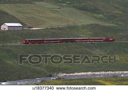 train, Switzerland, Uri, Urseren, Alps, The red Glacier Express Train travels through the scenic valley near the village of Hospental in the Swiss Alps. View Large Photo Image Stock Image - train, Switzerland, Uri, Urseren, Alps, The red Glacier Express Train travels through the scenic valley near the village of Hospental in the Swiss Alps.. Fotosearch
