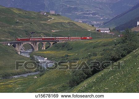 train, Switzerland, Uri, Urseren, Alps, The red Glacier Express Train travels through the scenic valley near the village of Hospental in the Swiss Alps. View Large Photo Image Stock Photo - train, Switzerland, Uri, Urseren, Alps, The red Glacier Express Train travels through the scenic valley near the village of Hospental in the Swiss Alps.. Fotosearch
