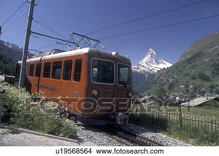 Picture -  train, Switzerland, Zermatt, Valais, Matterhorn, Alps, Gornergrat Bahn (train) travels through the mountain resort village of Zermatt with a view of the Matterhorn in the Swiss Alps.. Fotosearch