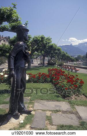 Vevey, Switzerland, Charlie Chaplin, Vaud, Lake Geneva, Statue of Charlie Chaplin holding a pink rose at the lakefront park along Lac Leman in Vevey in the Canton of Vaud. He is surrounded by beautiful red and white flowers. View Large Photo Image Stock Image - Vevey, Switzerland, Charlie Chaplin, Vaud, Lake Geneva, Statue of Charlie Chaplin holding a pink rose at the lakefront park along Lac Leman in Vevey in the Canton of Vaud. He is surrounded by beautiful red and white flowers.. Fotosearch