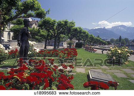 Vevey, Switzerland, Lake Geneva, Charlie Chaplin, Vaud, Statue of Charlie Chaplin holding a pink rose at the lakefront park along Lac Leman in Vevey in the Canton of Vaud. He is surrounded by beautiful red and white flowers. View Large Photo Image Stock Image - Vevey, Switzerland, Lake Geneva, Charlie Chaplin, Vaud, Statue of Charlie Chaplin holding a pink rose at the lakefront park along Lac Leman in Vevey in the Canton of Vaud. He is surrounded by beautiful red and white flowers.. Fotosearch
