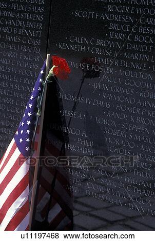 Vietnam Veterans Memorial Wall, Washington, DC, District of Columbia, A red carnation and the American Flag are placed by the names of loved ones who died in the Vietnam war on the Vietnam Veterans Memorial at West Potomac Park in Washington, D. C. View Large Photo Image Stock Photo - Vietnam Veterans Memorial Wall, Washington, DC, District of Columbia, A red carnation and the American Flag are placed by the names of loved ones who died in the Vietnam war on the Vietnam Veterans Memorial at West Potomac Park in Washington, D. C. . Fotosearch