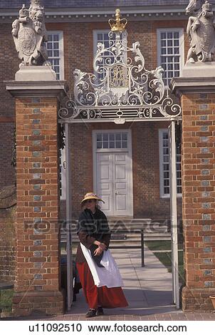 Stock Image -  Williamsburg, VA, Colonial Williamsburg, Virginia, Costumed interpreter at the gate of the Governor's Palace in the 18th century village of Colonial Williamsburg in Colonial Williamsburg Historic Area.. Fotosearch