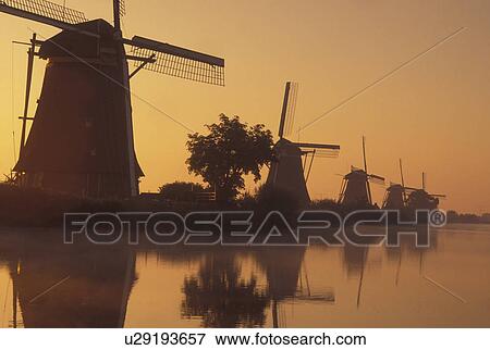 windmill, canal, Kinderdijk, Holland, Netherlands, Zuid-Holland, Europe, Mills of Kinderdijk, Working windmills along a canal in the early morning mist in Kinderdijk. View Large Photo Image Stock Photo - windmill, canal, Kinderdijk, Holland, Netherlands, Zuid-Holland, Europe, Mills of Kinderdijk, Working windmills along a canal in the early morning mist in Kinderdijk. . Fotosearch