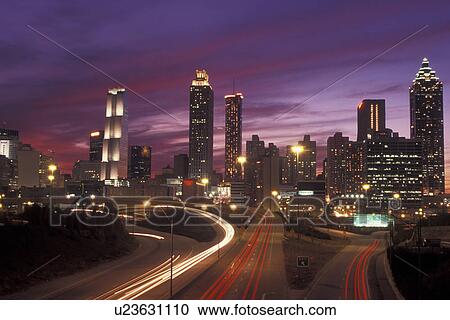 Stock Image -  Atlanta, GA, Georgia, Downtown skyline, Presidential Parkway, evening, expressway, streaks of red and white car lights. Fotosearch