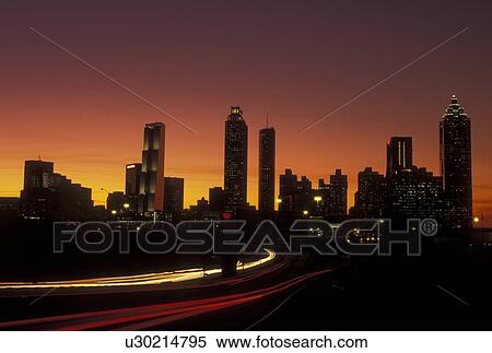 Stock Photography -  Atlanta, GA, Georgia, Downtown skyline, Freedom Parkway, evening, traffic, streaks of car lights along the expressway, road. Fotosearch