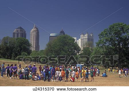Stock Image -  Atlanta, GA, Georgia, School volleyball game at Piedmont Park, downtown skyline. Fotosearch