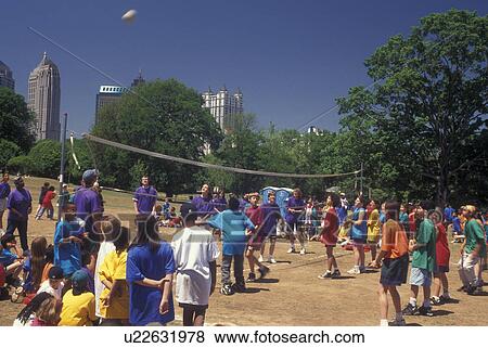 Stock Photo -  Atlanta, GA, Georgia, School volleyball game at Piedmont Park, downtown skyline. Fotosearch