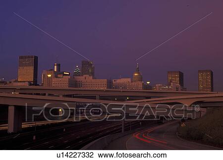 Stock Image -  Atlanta, GA, Georgia, skyline, downtown, streak of car lights along I-85/75 & I-20, sunset, expressway, interstate. Fotosearch