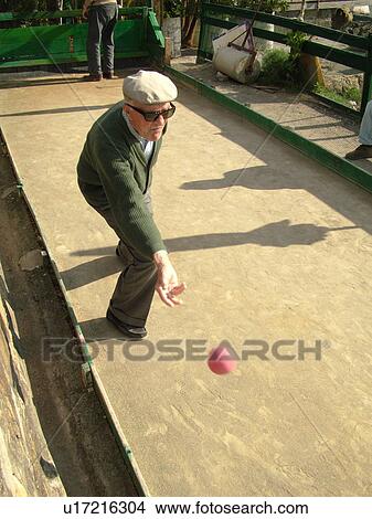 Picture -  bocce, Liguria, Italy, Sestri Levante, Riviera di Levante, Ligurian Riviera, Europe, 94 year old senior Italian man playing the game of Bocce on the waterfront in Sestri Levante along the Ligurian Sea.. Fotosearch