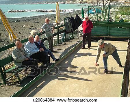 Picture -  bocce, Liguria, Italy, Sestri Levante, Riviera di Levante, Ligurian Riviera, Europe, Men playing the game of Bocce on the waterfront in Sestri Levante along the Ligurian Sea.. Fotosearch