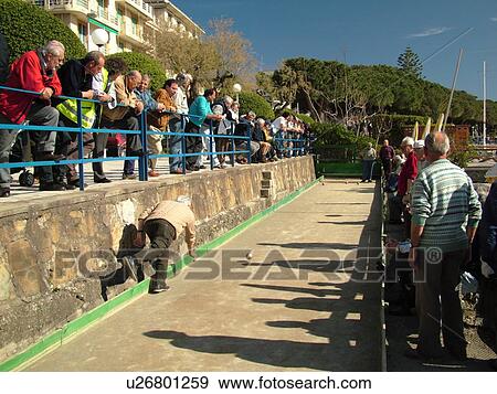 bocce, Liguria, Italy, Sestri Levante, Riviera di Levante, Ligurian Riviera, Europe, Men playing the game of Bocce on the waterfront in Sestri Levante along the Ligurian Sea. View Large Photo Image Stock Photo -  bocce, Liguria, Italy, Sestri Levante, Riviera di Levante, Ligurian Riviera, Europe, Men playing the game of Bocce on the waterfront in Sestri Levante along the Ligurian Sea.. Fotosearch