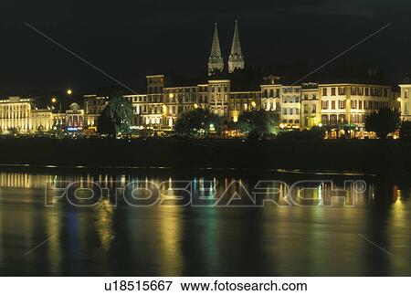 Stock Photo -  Burgundy, France, Macon, Saone-et-Loire, Bourgogne, Europe, wine region, Scenic view of the city of Macon along the Saone River in the evening.. Fotosearch