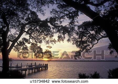 Stock Image -  Cumberland Island National Seashore, GA, Golden Isles, barrier island, Georgia, St. Marys River, Sea Camp Dock, sunset. Fotosearch